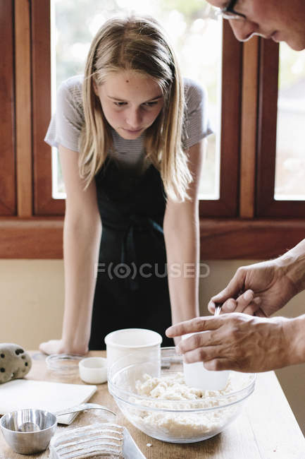 Man and woman making pastry in a kitchen. — Stock Photo