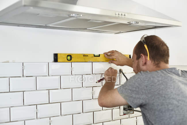 Hombre trabajando en una nueva cocina - foto de stock