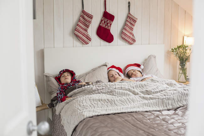 Christmas stockings above children heads. — Stock Photo
