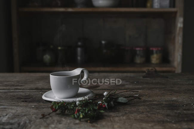 Чашка белого фарфора и блюдце на столе — стоковое фото