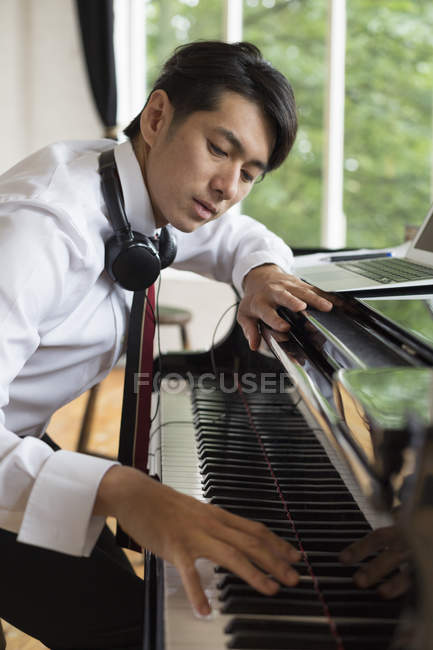 Homem tocando em um piano de cauda — Fotografia de Stock