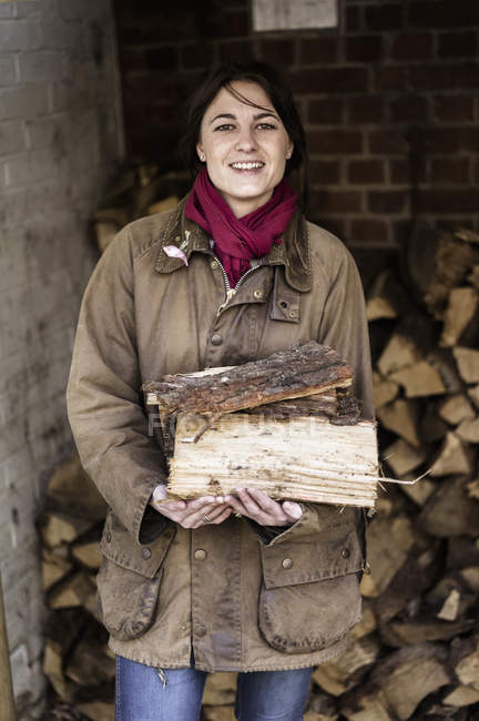 Mujer llevando troncos partidos - foto de stock