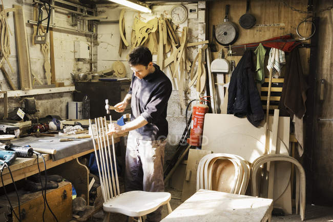Hombre trabajando en un taller de carpintería - foto de stock
