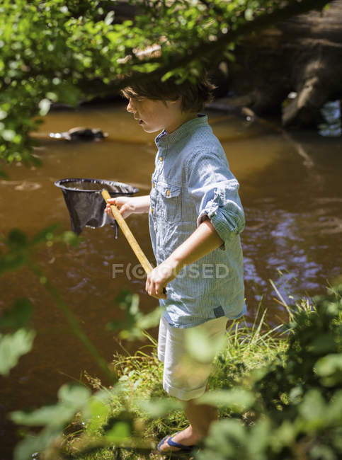 Niño sosteniendo red de pesca - foto de stock