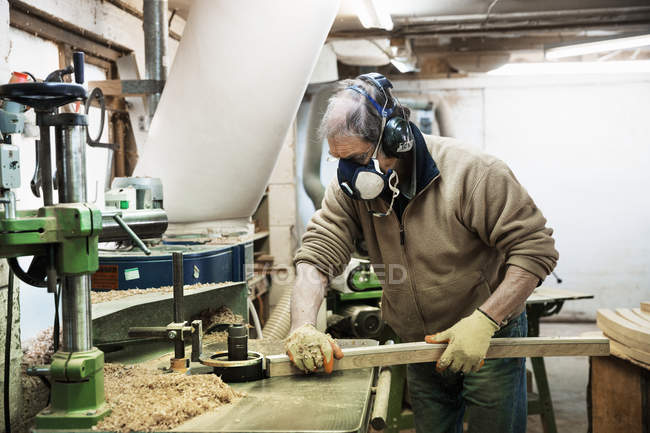 Homem trabalhando em um pedaço de madeira . — Fotografia de Stock