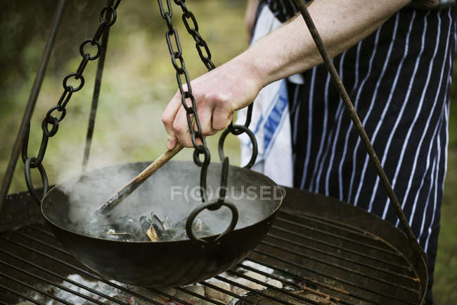 Chef cocinando mejillones negros - foto de stock