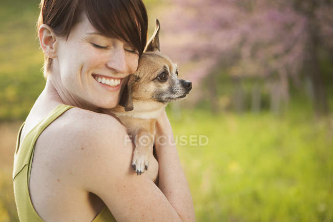Женщина держит маленькую собачку чихуахуа — стоковое фото