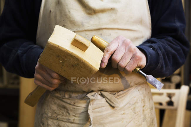 Homem segurando um martelo de madeira e cinzel . — Fotografia de Stock