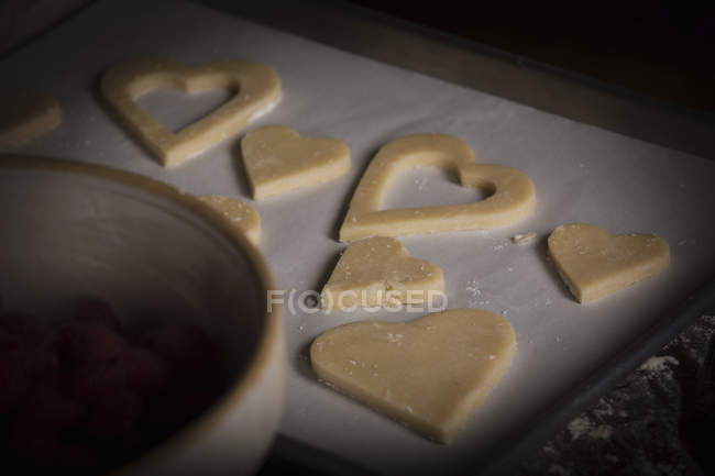 Heart shaped biscuits on baking tray — Stock Photo