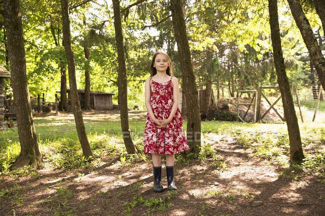 Chica de pie en la arboleda de árboles - foto de stock