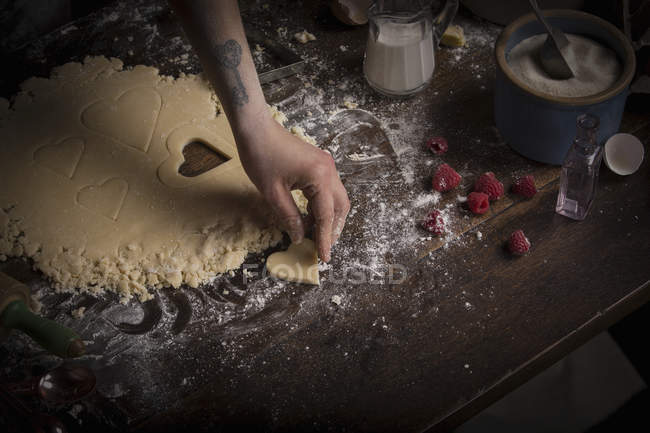 Mulher cortando biscoitos em forma de coração — Fotografia de Stock