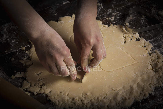 Mulher cortando biscoitos em forma de coração — Fotografia de Stock