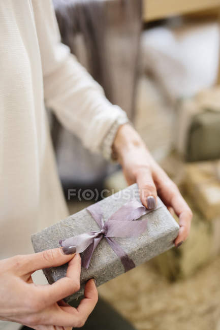 Femme tenant cadeau emballé cadeau — Photo de stock
