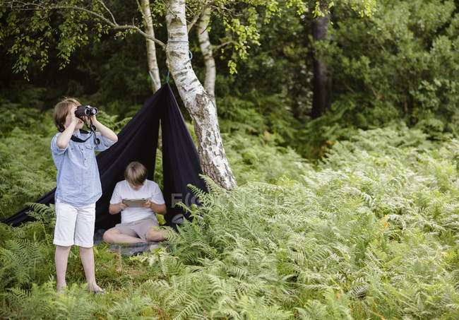 Dos chicos acampando en el bosque - foto de stock