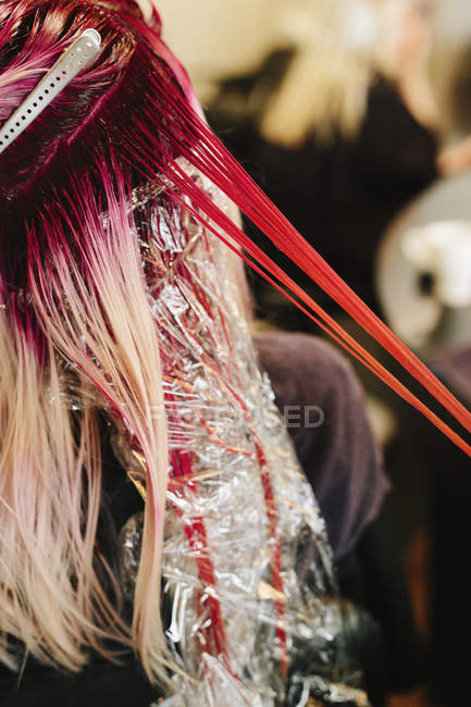 Colorista del pelo aplicando color rosa - foto de stock