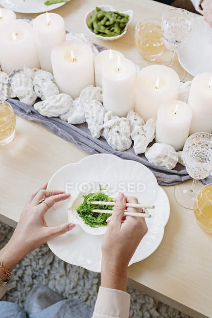 Frau verwendet Essstäbchen, um Gemüse zu essen — Stockfoto