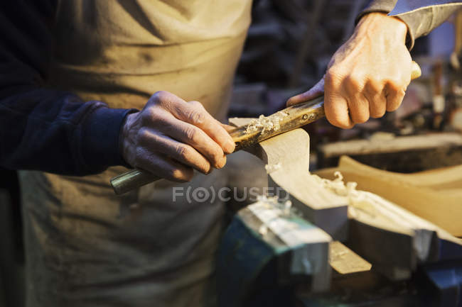 Чоловік працює над шматочком дерева — стокове фото