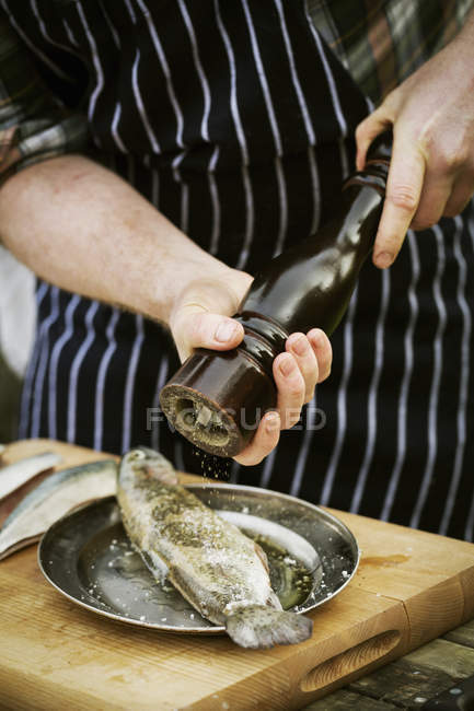 Шеф-повар с помощью солевой мельницы — стоковое фото
