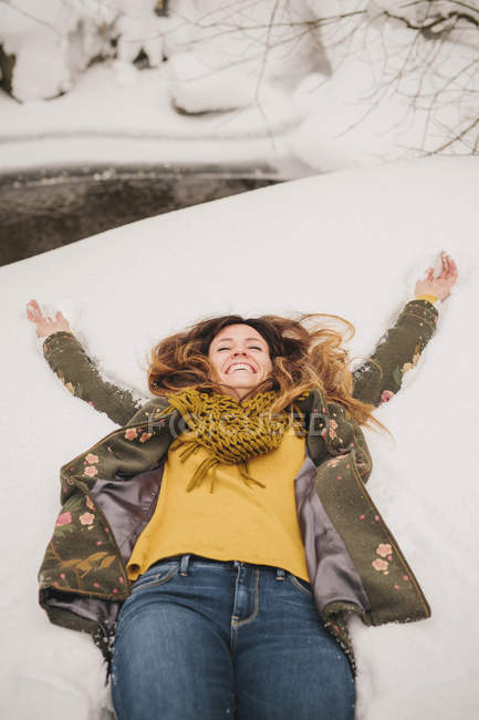 Mulher deitada em um banco de neve — Fotografia de Stock