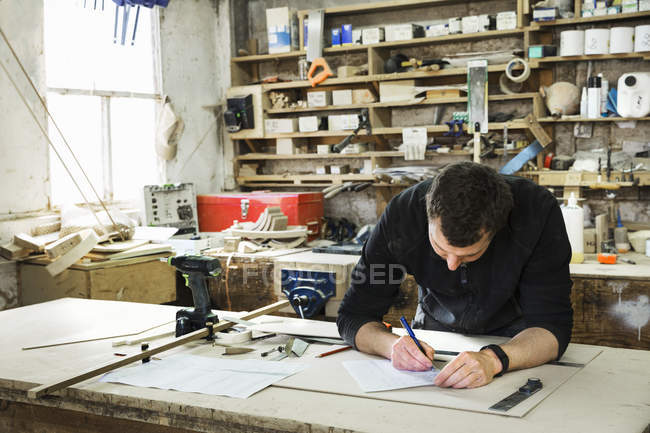 Homme travaillant dans un atelier de menuiserie — Photo de stock