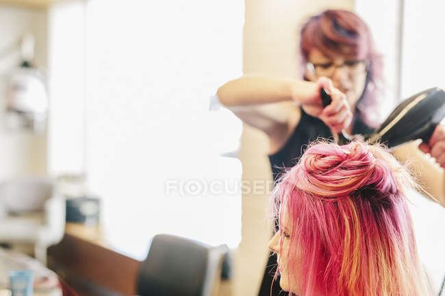 Hair stylist blowdrying hair — Stock Photo
