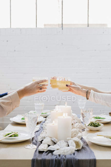 Personnes levant des verres en pain grillé — Photo de stock