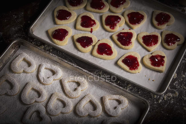 Heart shaped biscuits on a baking tray — Stock Photo