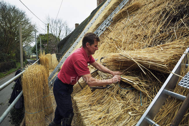 Uomo paglia un tetto — Foto stock