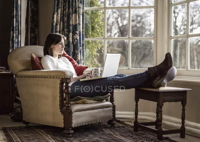 Mujer usando el ordenador portátil en casa - foto de stock
