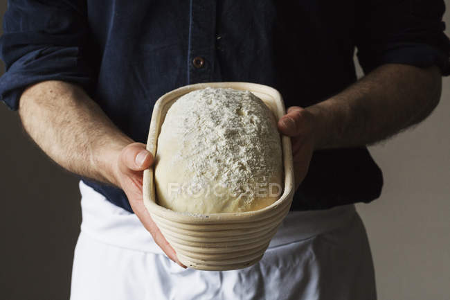 Пекарь держит буханку белого хлеба — стоковое фото