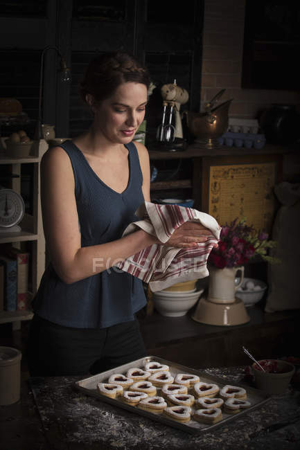 Woman wiping hands with tea towel — Stock Photo