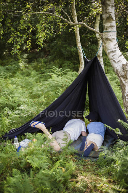 Мальчики лежат под брезентом — стоковое фото