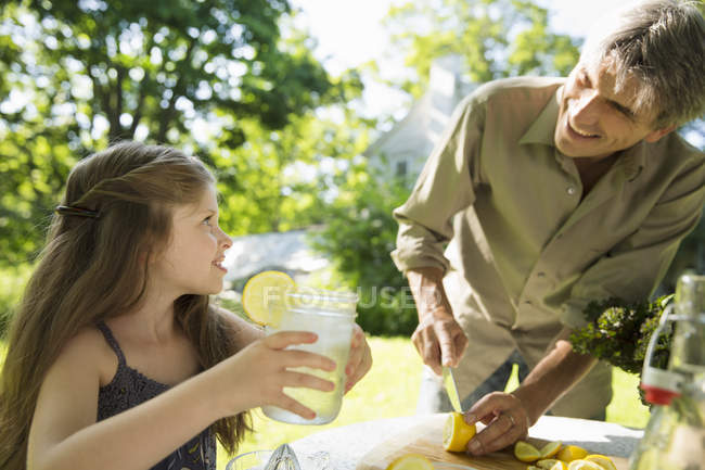Дівчина і дорослий чоловік роблять лимонад . — стокове фото