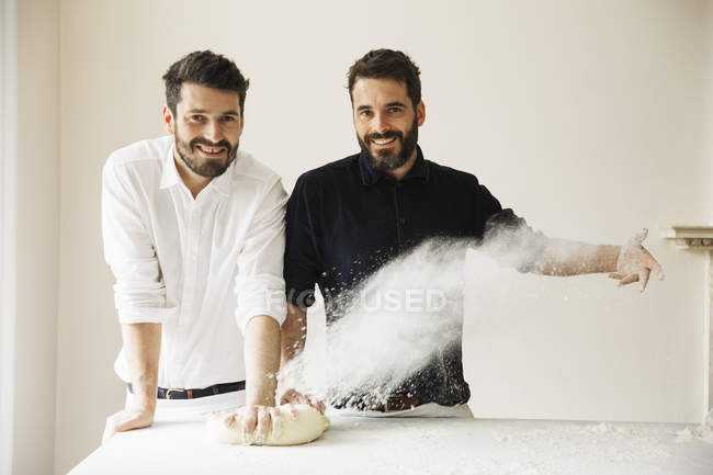 Пекари вытирают тесто из хлеба мукой — стоковое фото