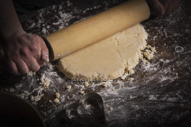 Woman rolling out dough with rolling pin — Stock Photo
