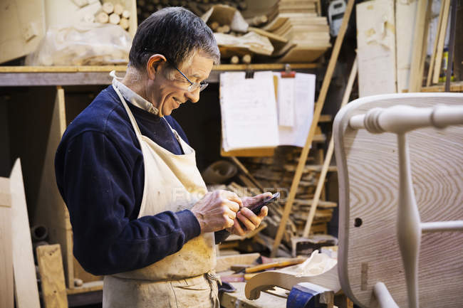 Homem trabalhando em uma cadeira de madeira — Fotografia de Stock