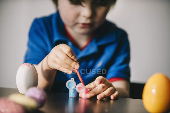 Boy painting eggs at Easter — Stock Photo