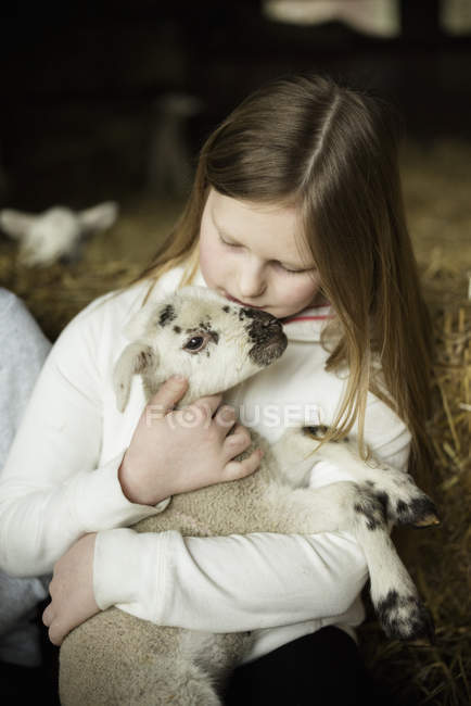 Girl and newborn lamb — Stock Photo