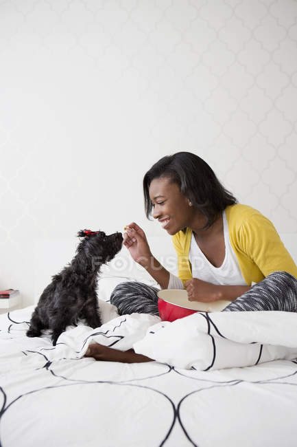 Mädchen hat Spaß mit schwarzem Hund — Stockfoto