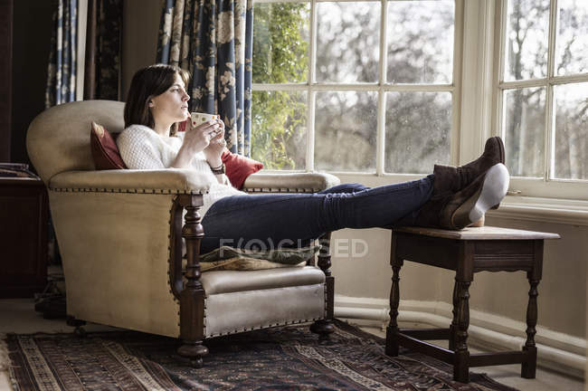Woman daydreaming and drinking cup of tea — Stock Photo
