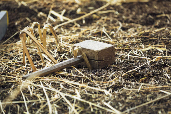 Деревянный молоток лежит на соломе — стоковое фото