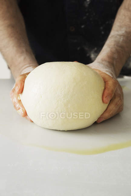 Baker shaping a large bread dough. — Stock Photo