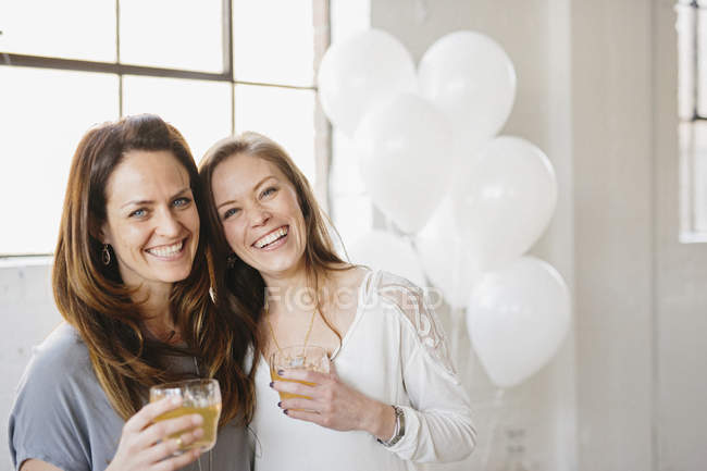 Women holding drinks on party — Stock Photo