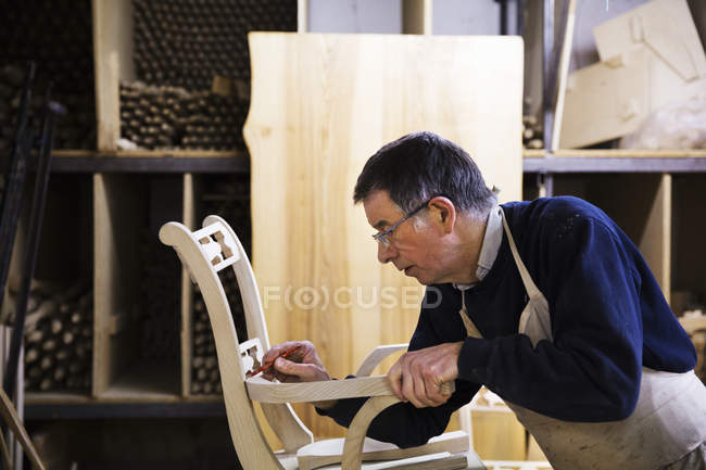 Чоловік працює на дерев'яному стільці — стокове фото