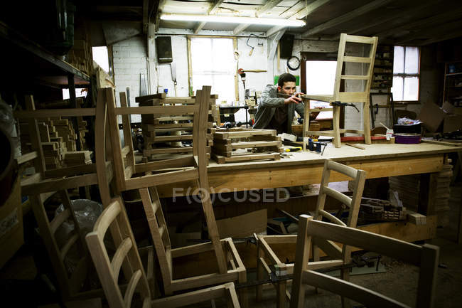 Hombre que trabaja en el taller de un fabricante de muebles - foto de stock