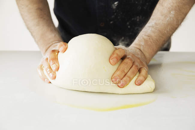 Panettiere impastando un grande impasto di pane . — Foto stock