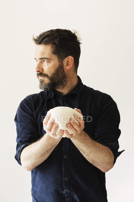 Baker holding a portion of bread dough — Stock Photo