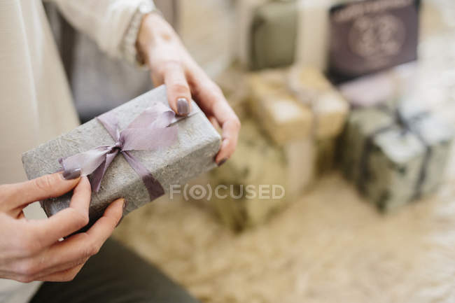 Жінка сидить з купою загорнутих подарунків — стокове фото