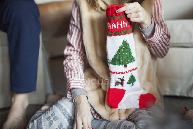 Gente desenvolviendo regalos de medias de Navidad - foto de stock