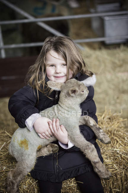 Petite fille et agneau nouveau-né — Photo de stock